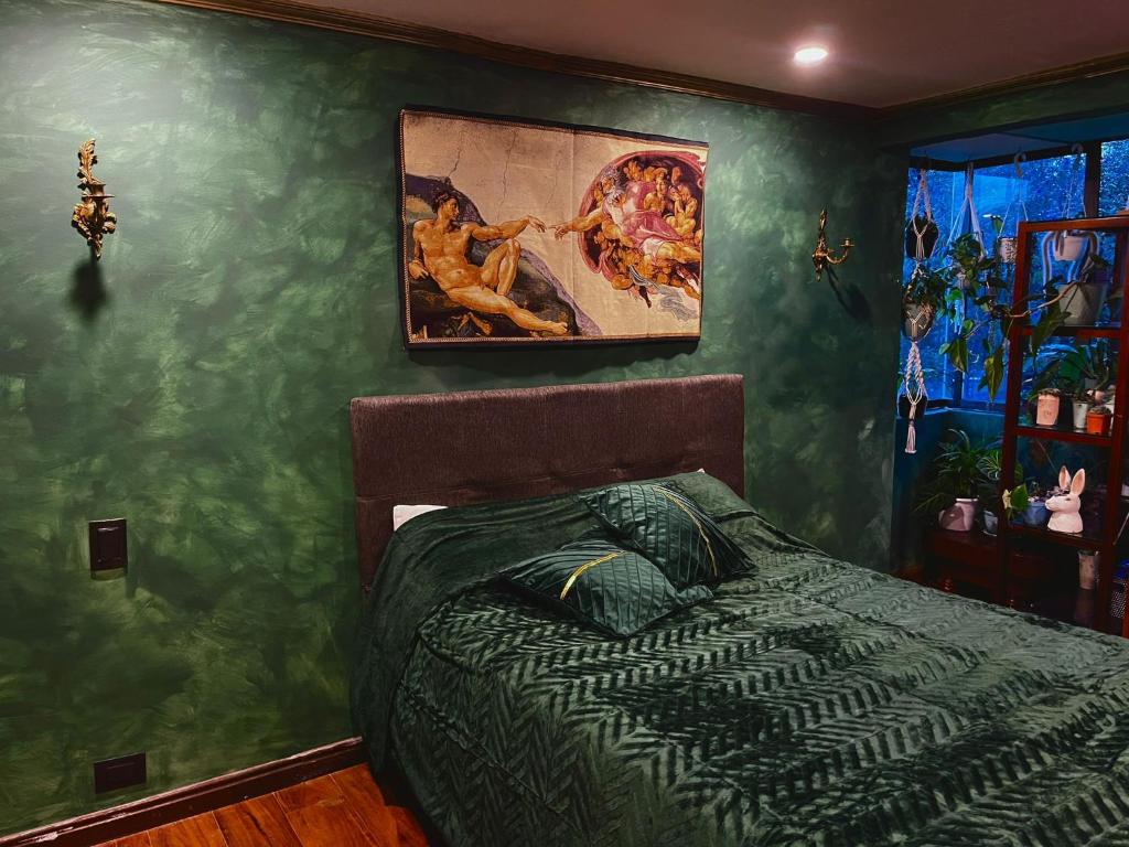 1 dormitorio con 1 cama y una pintura en la pared en Casa feliz, en Bogotá