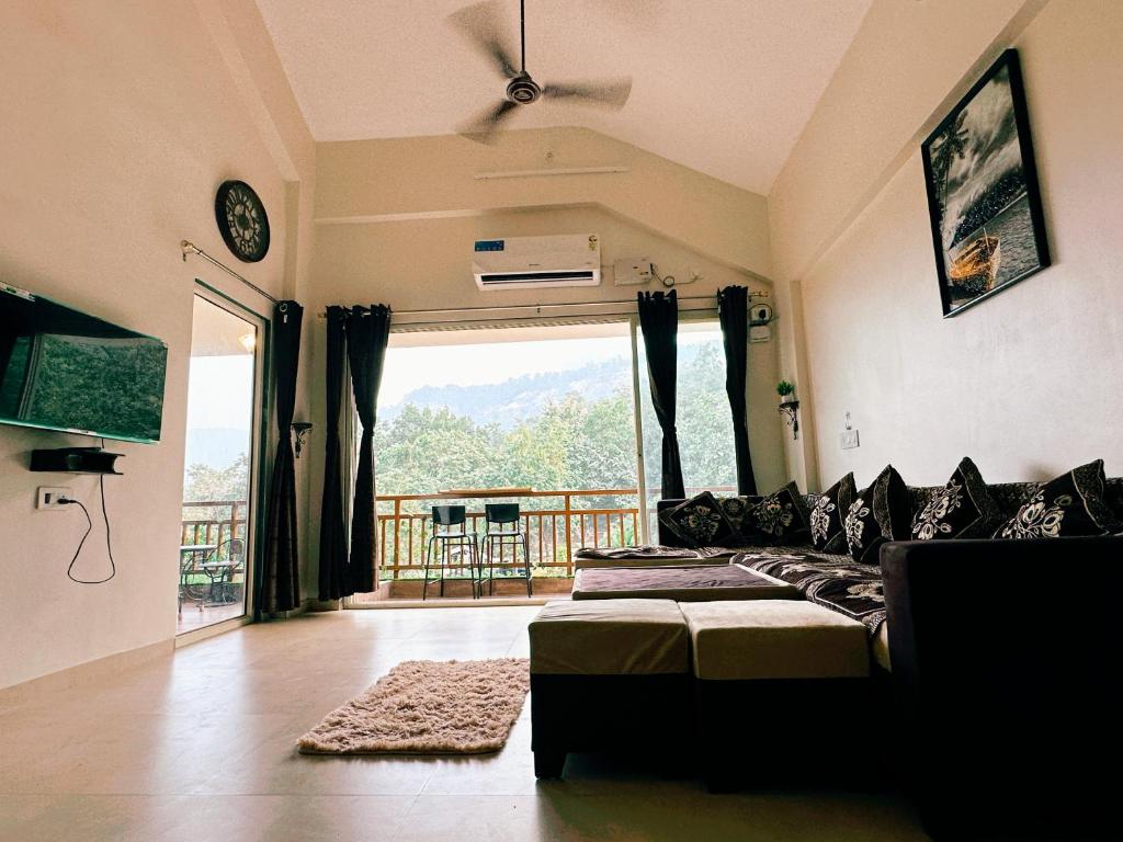 a living room with a couch and a large window at Mountainview Paradise in Karjat
