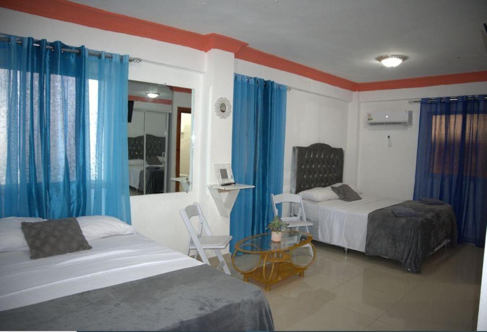 a hotel room with two beds and a mirror at Hotel Dubaird in Santo Domingo