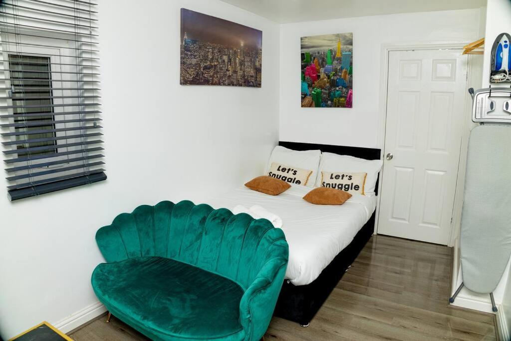 曼徹斯特的住宿－Cosy Manchester Haven for Two，一间卧室配有一张床和一把绿色椅子