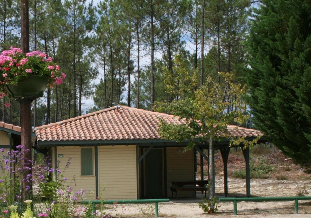 un petit hangar avec un toit rouge dans un jardin dans l'établissement Les genets, à Brocas