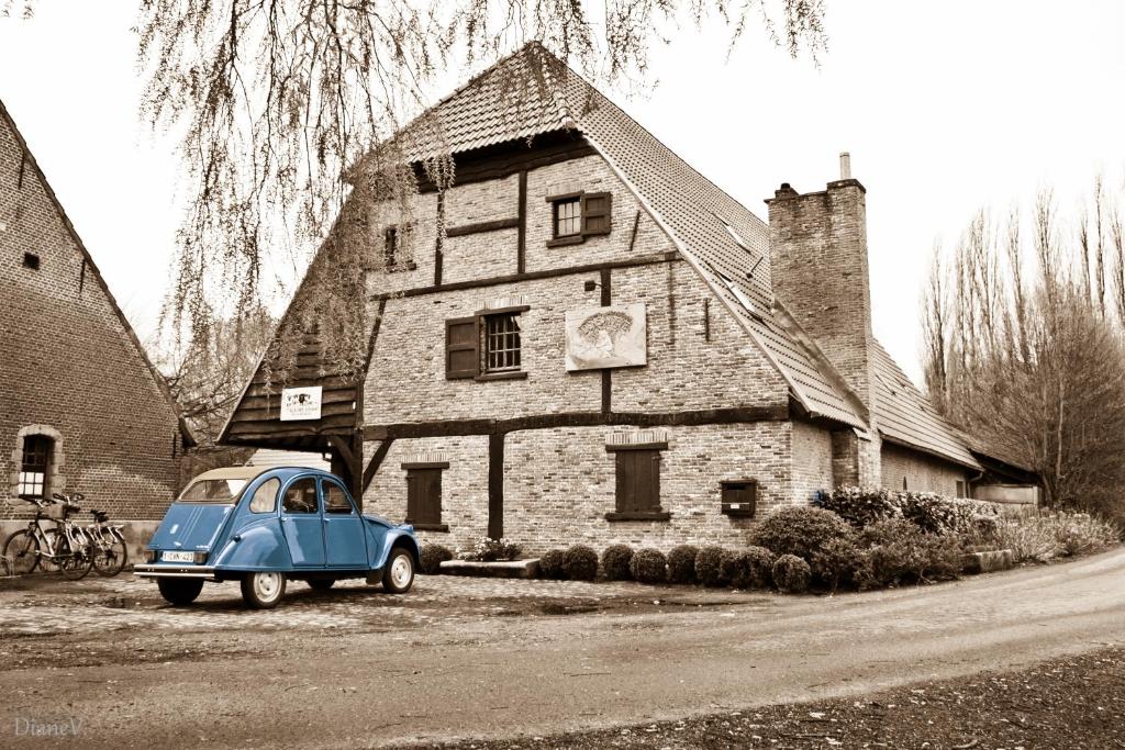 an old blue car parked in front of a house at Gastenlogies Blauwe Schaap in Ranst