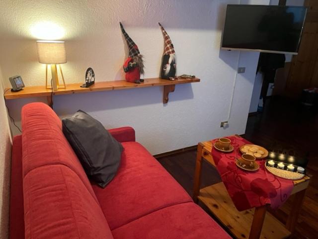 uma sala de estar com um sofá vermelho e uma mesa em PERLA DI MONTAGNA em Courmayeur