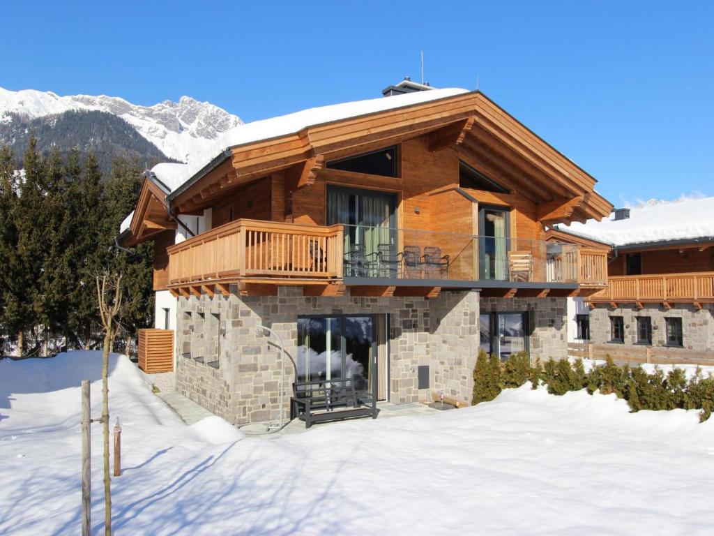 Cette maison en rondins possède un balcon dans la neige. dans l'établissement Chalet Schneelöwe XL, à Leogang