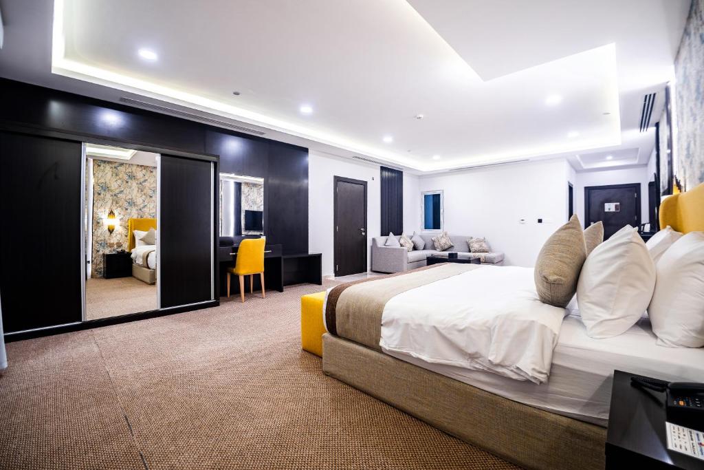 een slaapkamer met een groot bed en een woonkamer bij DAM hodoo دام الهــــــــدوء in Al Khobar