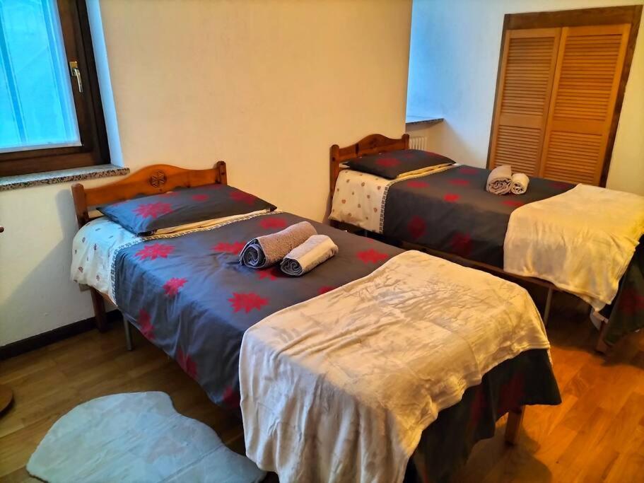 una habitación con tres camas en una habitación en Appartamento di montagna LO GROP, en Chambave