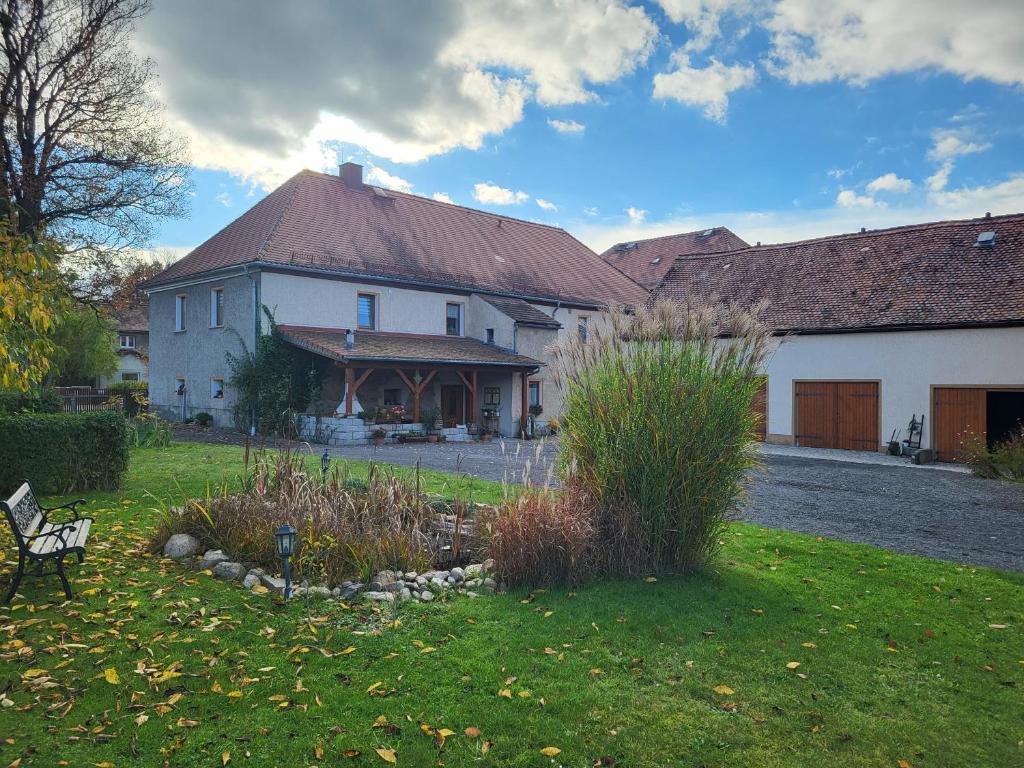 una gran casa blanca con un banco en un patio en Ferienwohnung Am Wasserturm mit kleinem Bauernhof, en Baruth