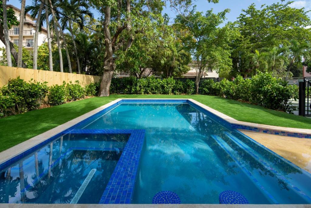 a swimming pool with blue water in a yard at Havana House Miami in Miami