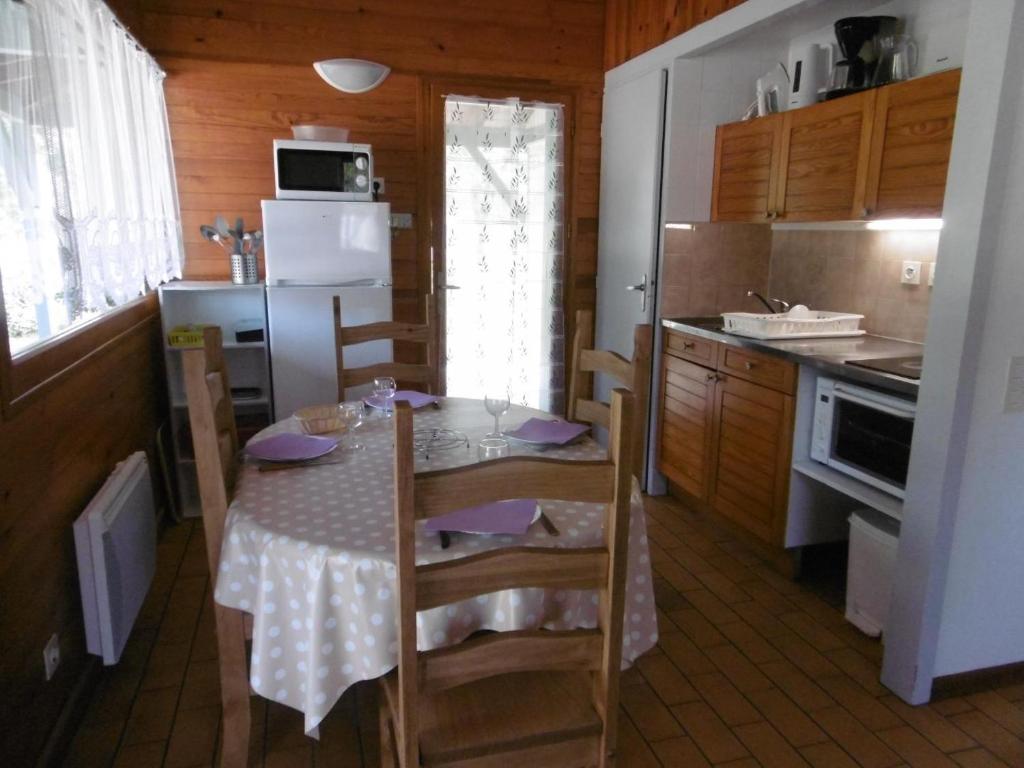a kitchen with a table and chairs in a kitchen at La callune in Brocas