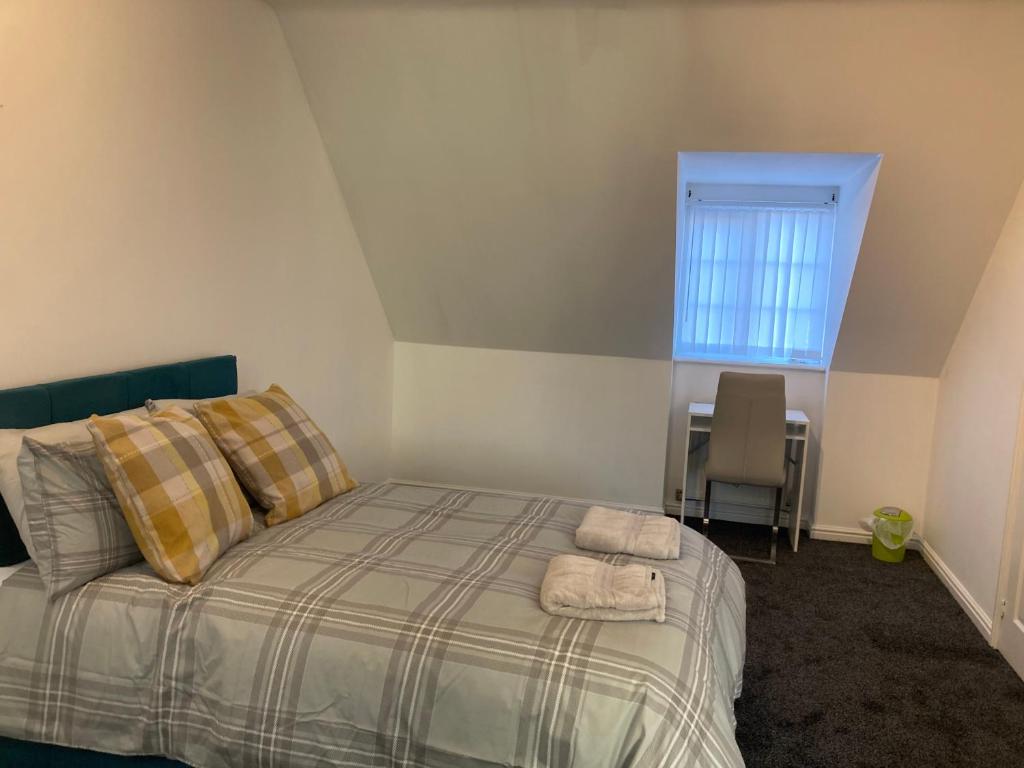 a bedroom with a bed with two towels on it at Spacious 4 Bed House, Sleep 8 Short & Long Stay, Free Parking ,5min Drive from Man City Stadium in Manchester