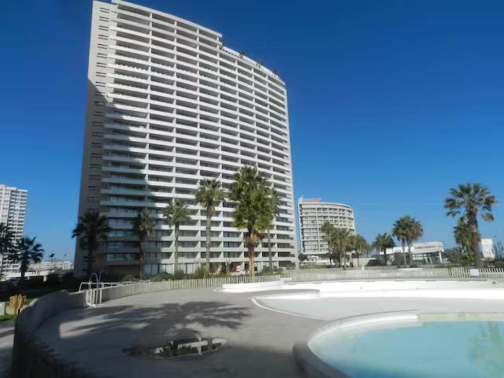 a large building with a pool in front of it at Departamento JARDIN DEL MAR, 2 Dormitorios in Coquimbo