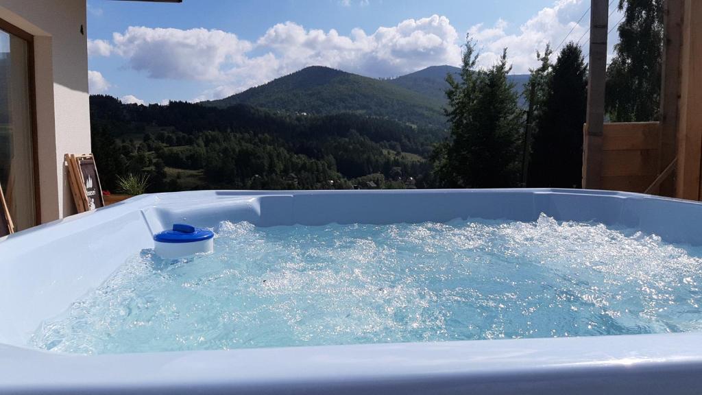 una bañera de hidromasaje con una taza de agua. en Zawoja Domki z Jacuzzi, en Zawoja