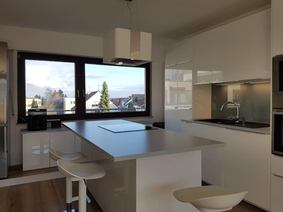 a kitchen with a counter and a large window at Studio Nähe Flughafen-Messe Stuttgart in Filderstadt