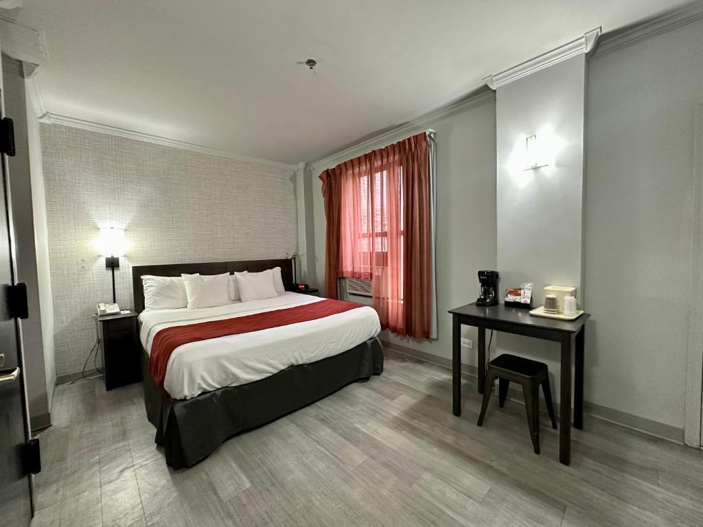 una habitación de hotel con una cama grande y una mesa en Heritage Hotel New York City, en Nueva York