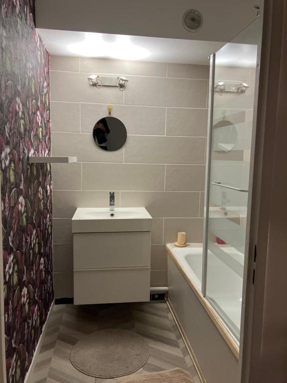 a small bathroom with a sink and a shower at Emplacement top avec parking au Stade de France 2mn de Paris 20 de Roissy CDG et 30 de La Défense in Saint-Denis