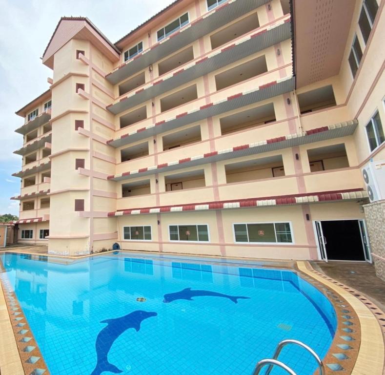two dolphins swimming in a swimming pool in front of a building at AA Pattaya Ville in Pattaya Central
