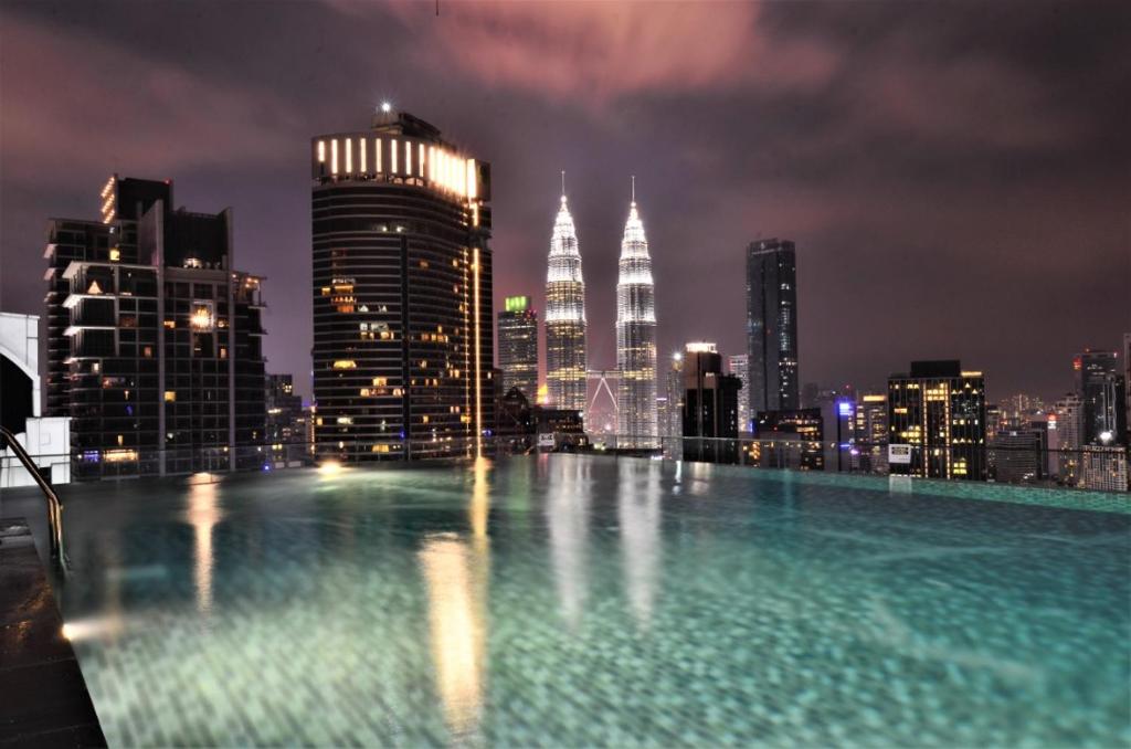 una piscina con vistas al perfil urbano por la noche en Dorsett Residences Service Suites Bukit Bintang Kl, en Kuala Lumpur