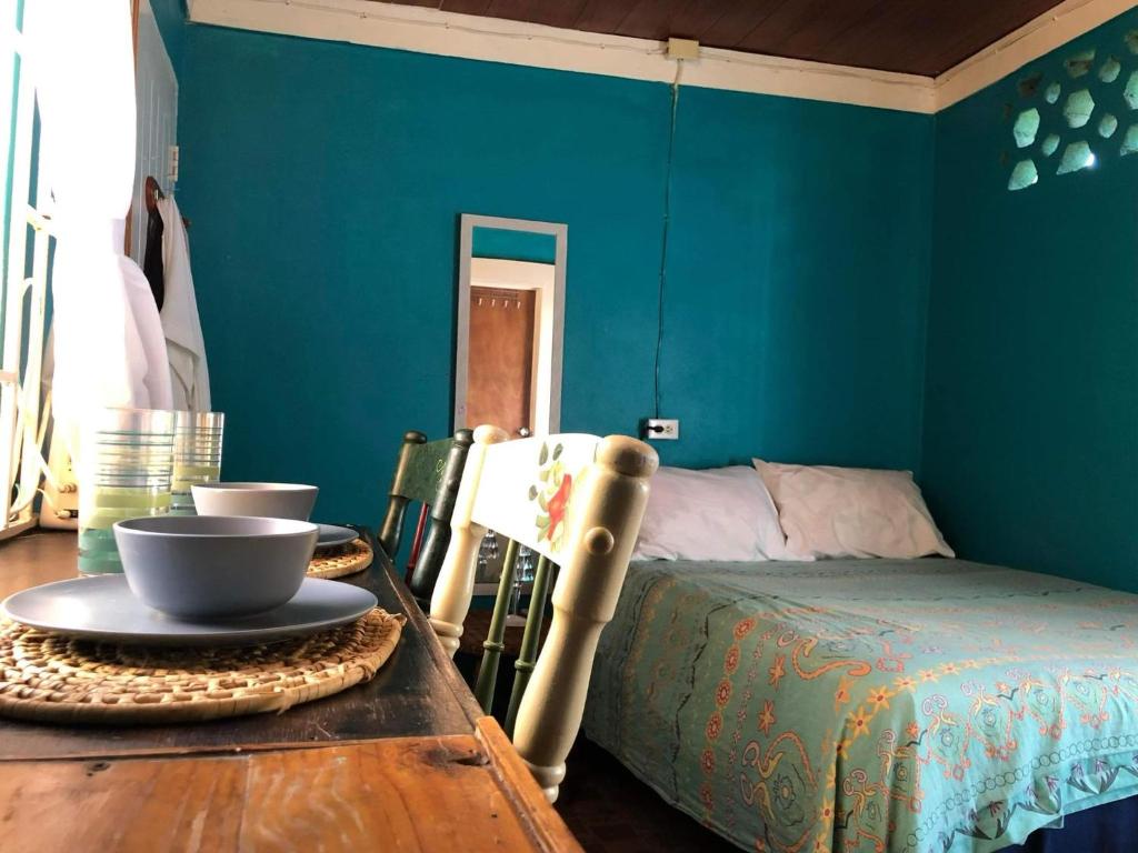 a bedroom with blue walls and a table with a bed at BnB SoMom Mobay Lodging in Montego Bay