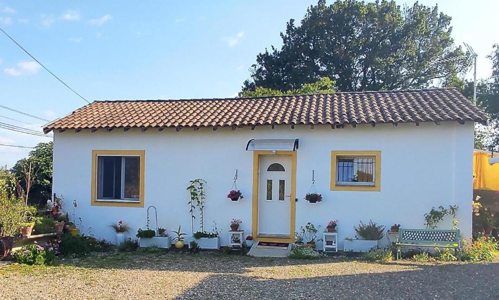 a small white house with a yellow door at Gite aux fleurs in Hagetmau