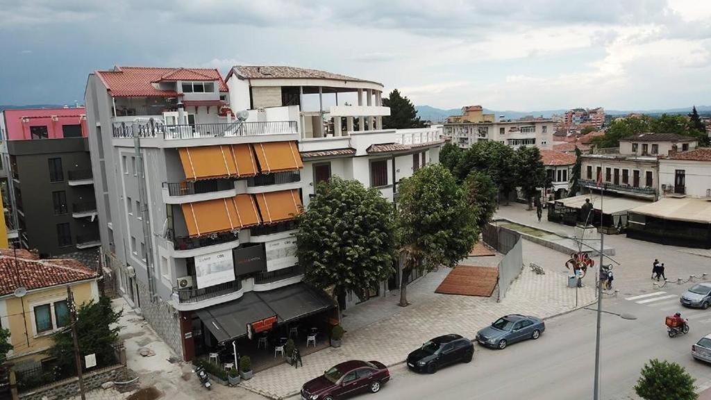 a city street with cars parked in front of a building at Lovely flat in the heart of Korca #1 in Korçë