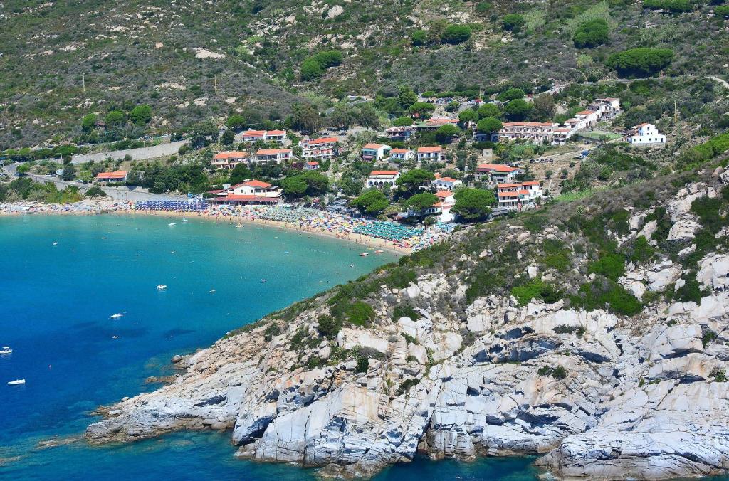 a group of houses on a hill next to the ocean at Hotel Baia Imperiale in Campo nell'Elba