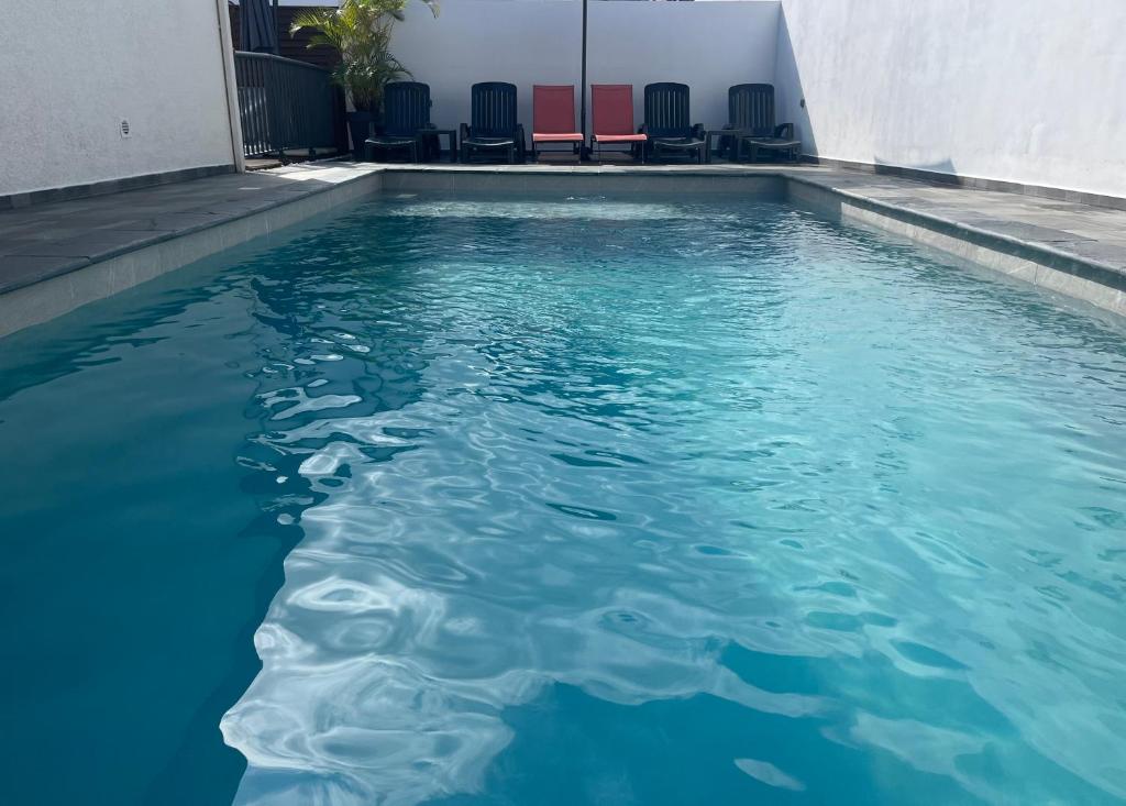 une piscine d'eau avec des chaises dans un bâtiment dans l'établissement Villa Fleurs de Cannes 4*, à Saint-Louis