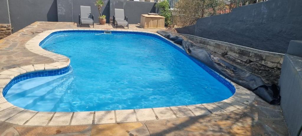 a swimming pool with blue water in a backyard at SapphireB@54 in Windhoek