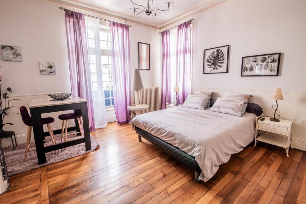 a bedroom with a bed and a table and a desk at Le Regisseur in Brissac-Quincé