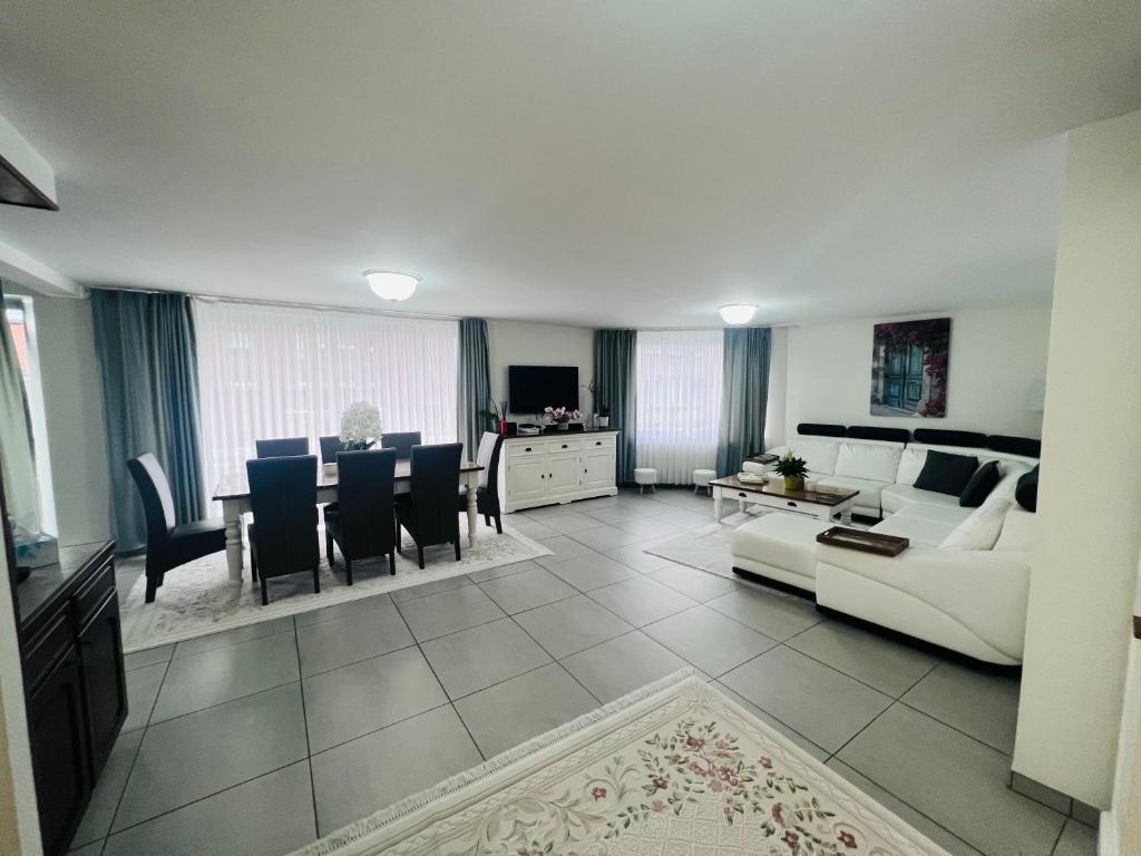 a living room with a white couch and a table at Windsor Residence Grimbergen in Grimbergen