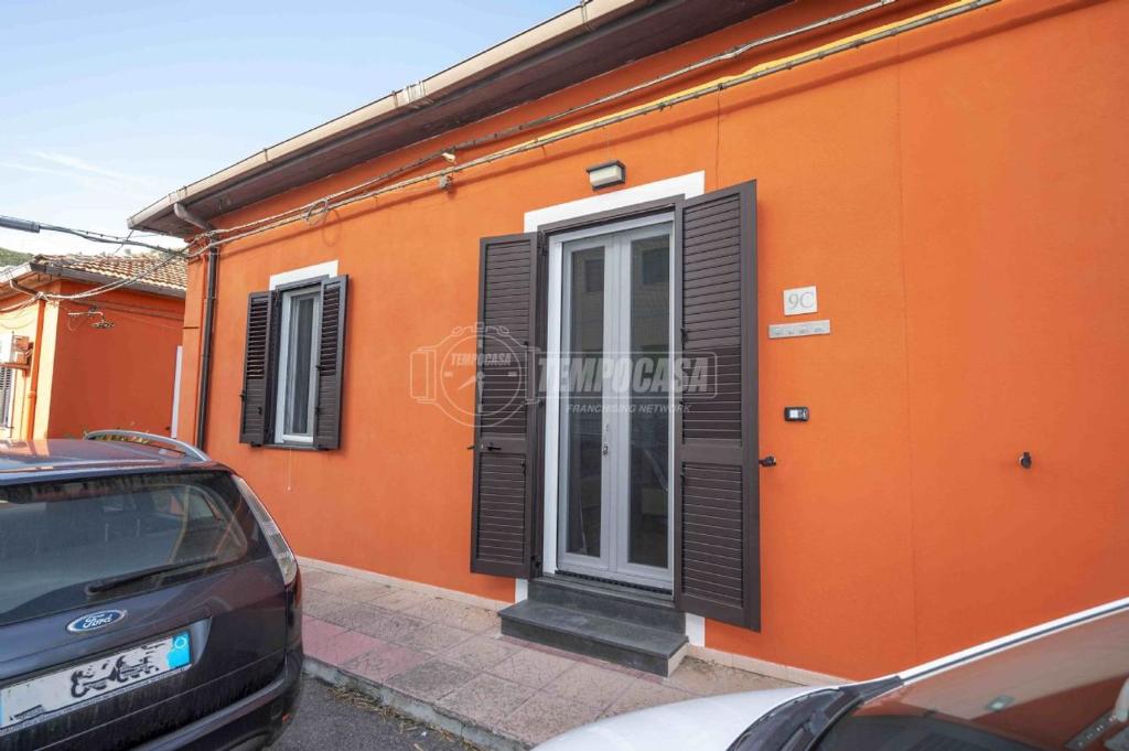 an orange building with a door and a car parked outside at CASA VACANZA Mamma MARIA in Messina