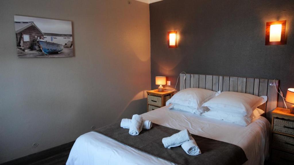 a bedroom with a bed with towels on it at La maison de mon enfance in Léon