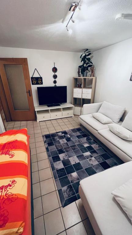 sala de estar con 2 camas y TV de pantalla plana en Apartment 61 Hannover, en Hannover