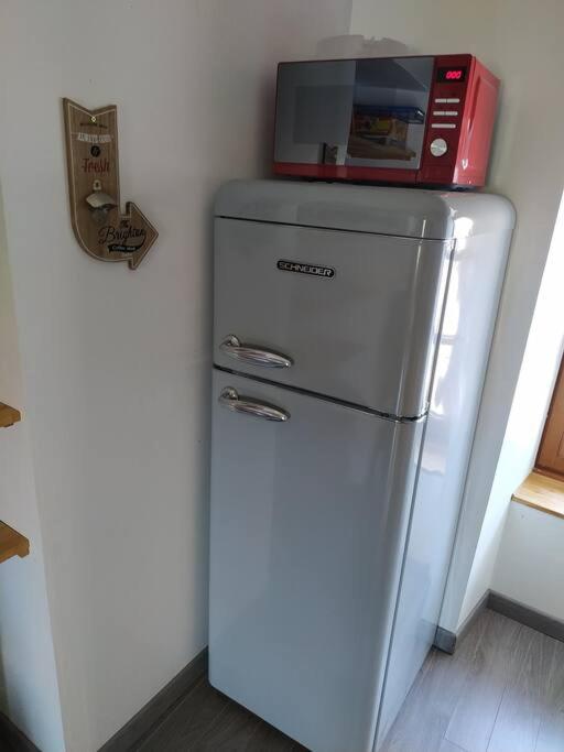 a microwave sitting on top of a refrigerator at La Parenthèse Clissonnaise plein centre historique in Clisson