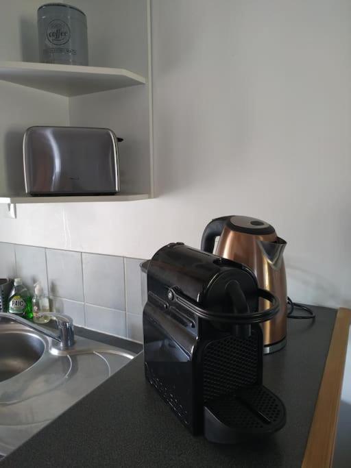 a toaster sitting on a kitchen counter next to a sink at La Parenthèse Clissonnaise plein centre historique in Clisson