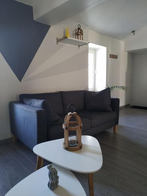 a living room with a couch and a table at La Parenthèse Clissonnaise plein centre historique in Clisson