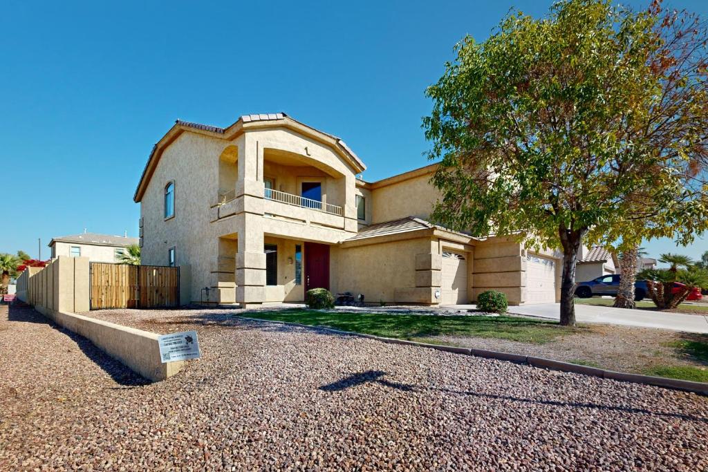 uma casa grande com uma árvore em frente em Desert Sanctuary em Litchfield Park