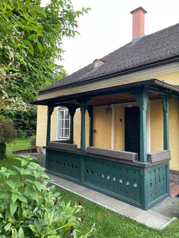 a house with a green porch with a window at hAUSzeit - Bungalow in Leoben