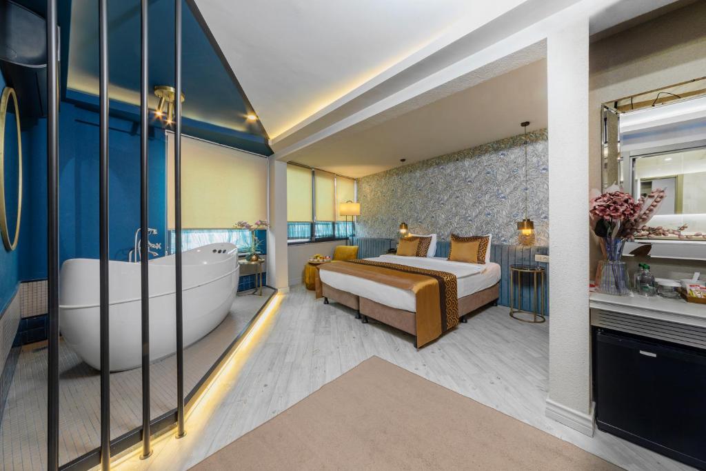 1 dormitorio con 1 cama grande y bañera en Ayramin Hotel Taksim, en Estambul