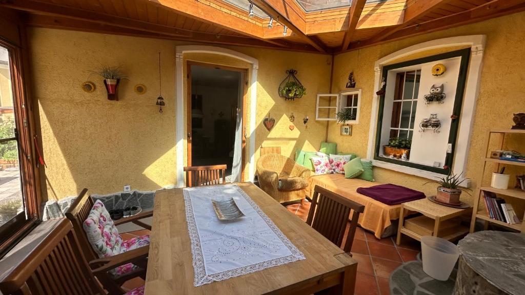 a patio with a wooden table and chairs and a room at hAUSzeit - Bungalow in Leoben