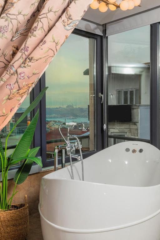 baño con bañera y ventana grande en Ayramin Hotel Taksim, en Estambul