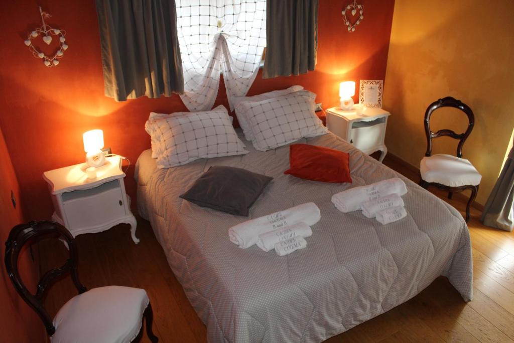 a bedroom with a white bed with two tables and two lamps at Holiday home Ca' del Cinema in Mombercelli