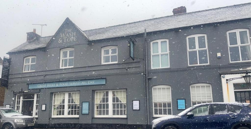 un edificio negro con un cartel en la nieve en The Wash & Tope, en Hunstanton