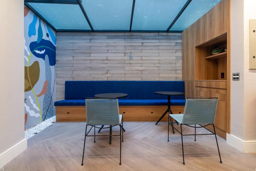 ein Zimmer mit 2 Stühlen und einem blauen Sofa in der Unterkunft 360 Praça da Árvore in São Paulo