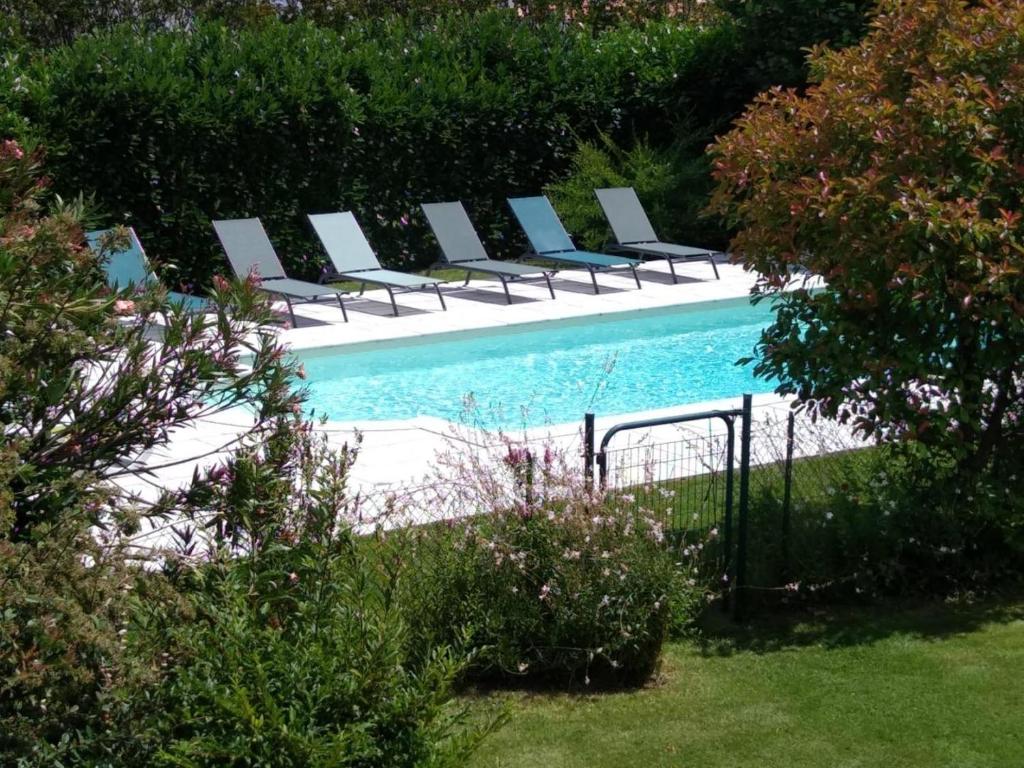 a row of chairs sitting next to a swimming pool at Arsuzon in Josse