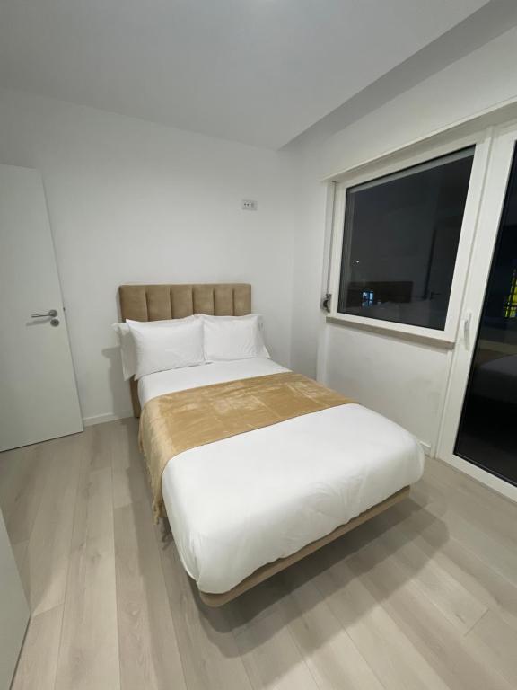 Un dormitorio blanco con una cama grande y una ventana en Modern Spacious Apartment, en Entroncamento