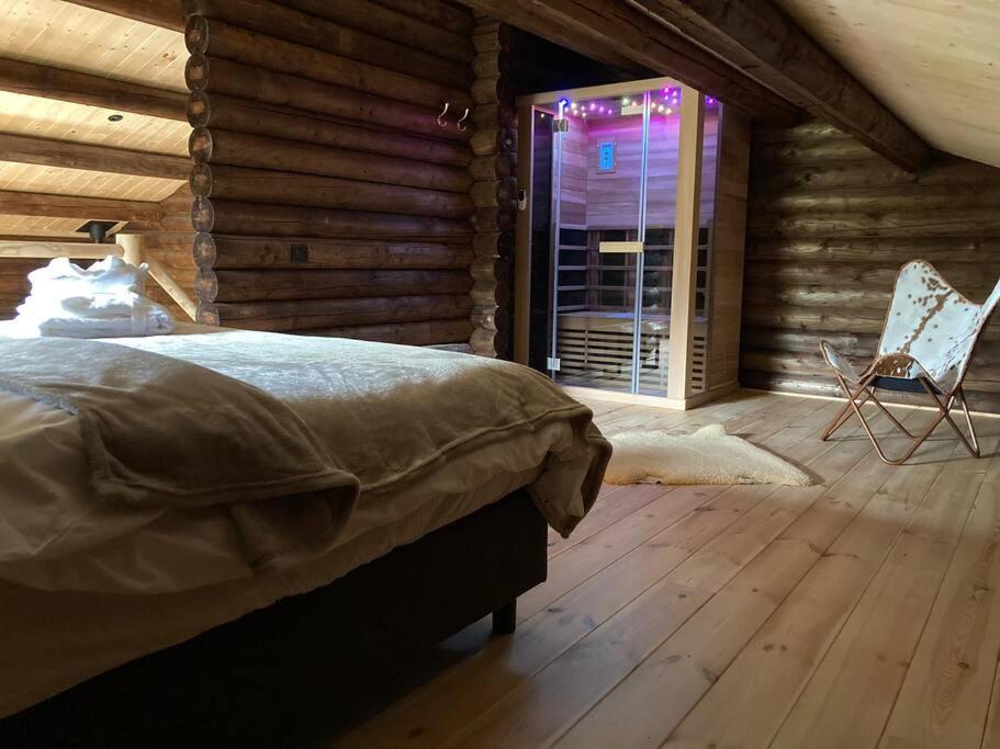 ein Schlafzimmer mit einem Bett in einem Blockhaus in der Unterkunft Chalet Amoureux (Région Durbuy) in Heure