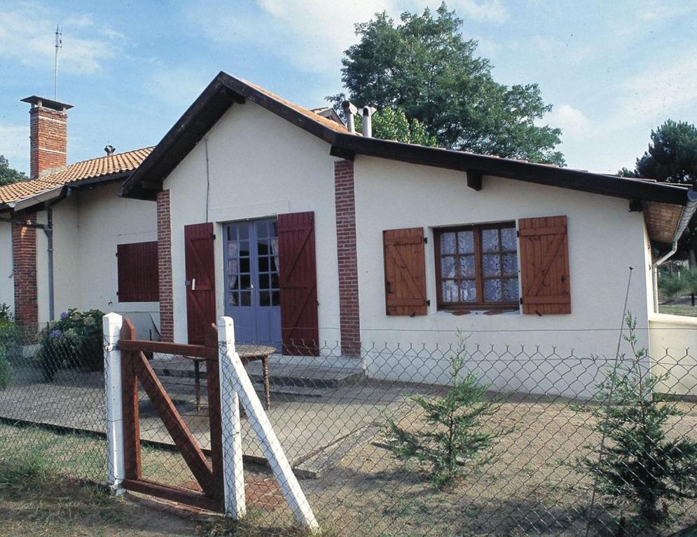 a small white house with a fence in front of it at Le point du jour in Lit-et-Mixe