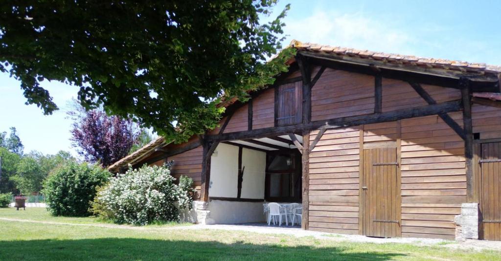 a small wooden building with a garage at Au bénédit ii in Vielle-Saint-Girons