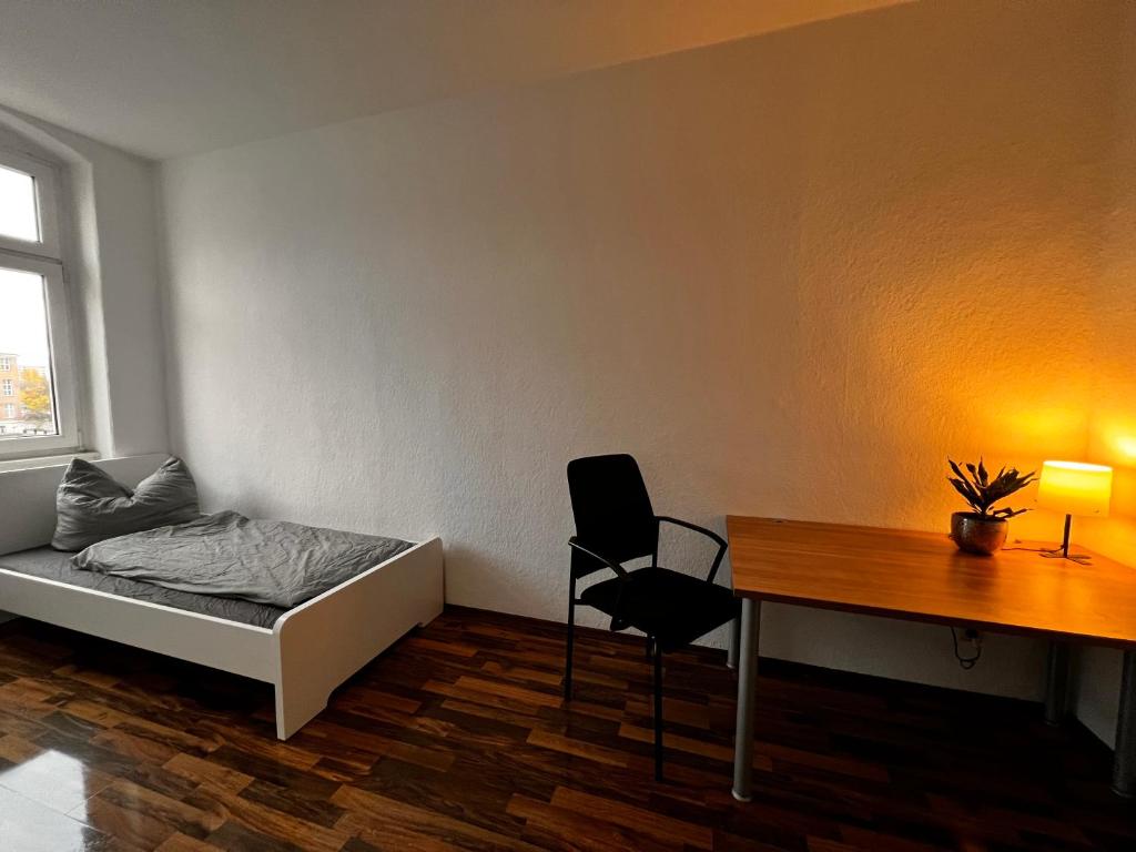 馬格德堡的住宿－Mitten in Magdeburg，客房设有一张床、一张桌子和一把椅子。
