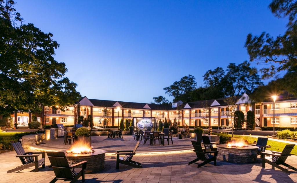 a hotel with tables and chairs in a courtyard at night at The Cove At Salem in Salem